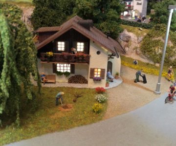 Plastico ferroviario "Un villaggio pieno di vita" casa e lampione